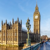 Photo of the Houses of Parliament and Big Ben, taken from Westminster bridge, with a bright blue sky.