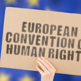 A sign being held up which reads: "European Convention on Human Rights"